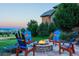 Stunning backyard with colorful Adirondack chairs surrounding a stone fire pit at 4839 Bandera Pl, Parker, CO 80134