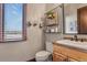 Bright bathroom featuring a wooden vanity, updated fixtures, and stylish decor at 4839 Bandera Pl, Parker, CO 80134
