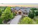 Beautiful home with stone facade, porte-cochère, professional landscaping, and mature trees at sunset at 4839 Bandera Pl, Parker, CO 80134