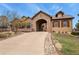 A beautiful stone-accented home featuring a porte-cochère and well-manicured lawn with rock detail at 4839 Bandera Pl, Parker, CO 80134
