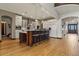 Spacious kitchen with a center island, breakfast bar, and white cabinetry with wood floors at 4839 Bandera Pl, Parker, CO 80134