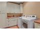 A well-organized laundry room with white cabinets, countertop space, and modern appliances at 4839 Bandera Pl, Parker, CO 80134