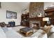 Inviting living room featuring a stone fireplace and built-in shelving for stylish storage at 4839 Bandera Pl, Parker, CO 80134