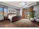 Bright main bedroom with a skylight, dark wood furniture, and access to the outdoor living space at 4839 Bandera Pl, Parker, CO 80134