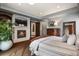 Spacious main bedroom featuring a cozy fireplace, TV, and comfortable bed at 4839 Bandera Pl, Parker, CO 80134