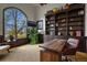 Spacious home office with custom built-ins, a large window, and a comfortable seating area at 4839 Bandera Pl, Parker, CO 80134