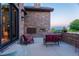 Outdoor stone patio featuring a fireplace, comfortable seating, and picturesque views of the landscape at 4839 Bandera Pl, Parker, CO 80134