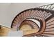 Beautiful spiral staircase featuring carpeted steps, wooden railing, and elegant wrought iron spindles at 4839 Bandera Pl, Parker, CO 80134