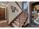 Elegant staircase with wrought iron railing and decorative details, leading to the upper level at 4839 Bandera Pl, Parker, CO 80134