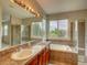 Bathroom features a tub, glass shower, double vanity, with large windows at 11649 E 111Th Ave, Commerce City, CO 80640