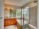 Bathroom features a tub, glass shower, and double vanity with a large window at 11649 E 111Th Ave, Commerce City, CO 80640