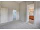 A bright carpeted bedroom showing ensuite bathroom and walk-in closet entrances at 11649 E 111Th Ave, Commerce City, CO 80640