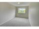 Bedroom featuring large window, carpet flooring, and neutral color palette at 11649 E 111Th Ave, Commerce City, CO 80640