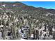 Aerial view of the house, nestled amongst trees, surrounded by mountain landscape at 2218 Witter Gulch Rd, Evergreen, CO 80439