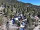 An aerial view of the home showing the surrounding trees and outdoor living spaces at 2218 Witter Gulch Rd, Evergreen, CO 80439