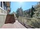 Wooden deck with stairs and railings showcase scenic mountain views through evergreen trees, blending nature and architecture at 2218 Witter Gulch Rd, Evergreen, CO 80439