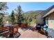 Wooden back deck features outdoor seating, grill, and scenic mountain views, perfect for relaxation and entertaining at 2218 Witter Gulch Rd, Evergreen, CO 80439