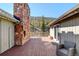 Spacious wood deck with mountain views, stone chimney, outdoor seating, and exterior lighting for ambiance and entertainment at 2218 Witter Gulch Rd, Evergreen, CO 80439