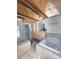 Bright bathroom featuring tile floors, a glass shower, and a large soaking tub beneath a wood-beam ceiling at 2218 Witter Gulch Rd, Evergreen, CO 80439