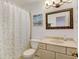 Cozy bathroom featuring vanity, decorative mirror, shower with curtain, and a tiled floor at 2218 Witter Gulch Rd, Evergreen, CO 80439