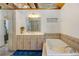 Bathroom featuring a large mirror, a vanity with cabinets, and a tub at 2218 Witter Gulch Rd, Evergreen, CO 80439