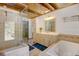 Bathroom featuring a large mirror, a vanity with cabinets, a tub, and a glass shower at 2218 Witter Gulch Rd, Evergreen, CO 80439