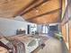 Bright bedroom with wood-beamed ceiling, a large window, and an ornate bedspread at 2218 Witter Gulch Rd, Evergreen, CO 80439