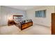 Cozy bedroom with a wood bed frame, soft carpet, and light blue accent wall at 2218 Witter Gulch Rd, Evergreen, CO 80439