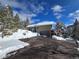 Charming home with a driveway and snowy surroundings under a bright sky at 2218 Witter Gulch Rd, Evergreen, CO 80439