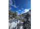 Scenic view of a home nestled among snow-covered trees against a blue sky, creating a winter wonderland at 2218 Witter Gulch Rd, Evergreen, CO 80439