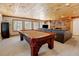 Game room featuring a pool table, mounted TV, stone fireplace, and wood ceiling at 2218 Witter Gulch Rd, Evergreen, CO 80439
