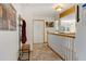 Hallway with stone tile flooring, white walls, and a wood accent beam leading to a dining area at 2218 Witter Gulch Rd, Evergreen, CO 80439