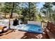 Hot tub on wooden deck surrounded by trees offers relaxation and scenic views in a snowy mountain setting at 2218 Witter Gulch Rd, Evergreen, CO 80439