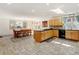 Spacious kitchen and dining area with tile flooring, wood cabinets and a large window looking out onto the trees at 2218 Witter Gulch Rd, Evergreen, CO 80439