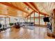 Spacious living room featuring vaulted ceilings, hardwood floors, a stone fireplace, and large windows for ample light at 2218 Witter Gulch Rd, Evergreen, CO 80439