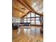 Spacious living room featuring wood ceiling, large windows, hardwood floors and stone fireplace at 2218 Witter Gulch Rd, Evergreen, CO 80439