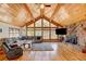 Living room with vaulted wood ceilings, stone fireplace and large windows at 2218 Witter Gulch Rd, Evergreen, CO 80439