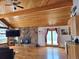 Living room featuring a stone fireplace, wood ceiling, and access to the outdoors at 2218 Witter Gulch Rd, Evergreen, CO 80439