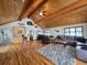 Open-concept living room with wood ceiling, hardwood floors, and bar area at 2218 Witter Gulch Rd, Evergreen, CO 80439