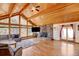 Bright living room with stone fireplace, hardwood floors, vaulted ceilings and scenic views through large windows at 2218 Witter Gulch Rd, Evergreen, CO 80439