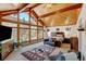 Vaulted ceiling main bedroom offers amazing views from large windows, a moose themed rug and comfortable furnishings at 2218 Witter Gulch Rd, Evergreen, CO 80439