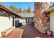 Patio with a stone fireplace, exterior lights, and sliding glass door to the home's interior at 2218 Witter Gulch Rd, Evergreen, CO 80439