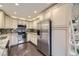 Well-lit kitchen with stainless steel appliances, white cabinets, dark wood flooring, and granite countertops at 12668 W 1St Pl # 81, Denver, CO 80228