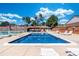 Community pool featuring lounge chairs, shade structure, bathhouse, and tennis court, ideal for relaxing and recreation at 12668 W 1St Pl # 81, Denver, CO 80228