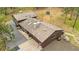 Aerial view of a brown home with an American flag, stone chimney, and a spacious gravel driveway at 2013 Swede Gulch Rd, Evergreen, CO 80439