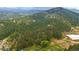 Expansive aerial view of heavily wooded acreage with horse property and paddocks nestled in the Colorado mountains at 2013 Swede Gulch Rd, Evergreen, CO 80439