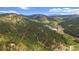 Scenic aerial view of horse property and paddocks nestled amongst pine trees in the Colorado mountain range at 2013 Swede Gulch Rd, Evergreen, CO 80439