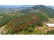 Expansive aerial view of heavily wooded acreage with horse property and paddocks nestled in the Colorado mountains at 2013 Swede Gulch Rd, Evergreen, CO 80439