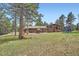 Spacious backyard features a patio and outdoor dining area, set against a backdrop of tall trees at 2013 Swede Gulch Rd, Evergreen, CO 80439