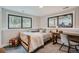 This bedroom has natural light, wooden furniture and neutral walls, with a large window overlooking the trees at 2013 Swede Gulch Rd, Evergreen, CO 80439